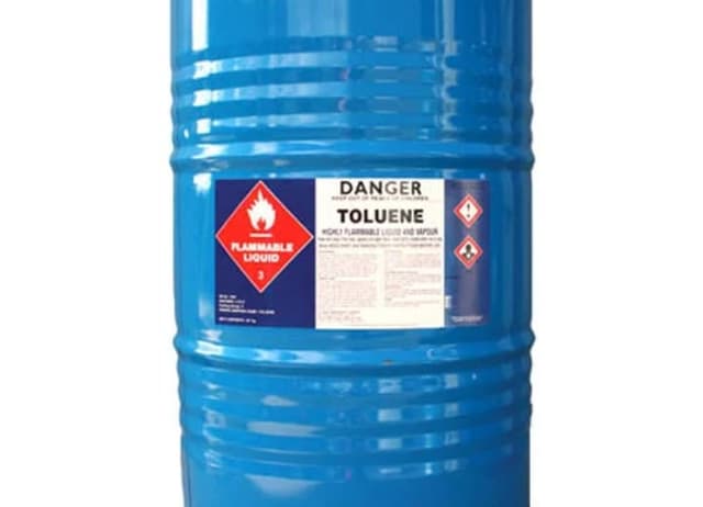 Blue drum of toluene with hazard labels